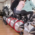 トレーニングジムで自転車を漕ぐ男女
